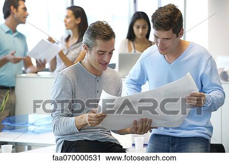 Male colleagues looking at blueprint together View Large Photo Image Stock Image - Male colleagues looking at blueprint together. Fotosearch