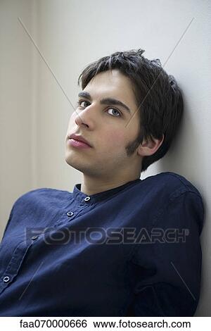 Male leaning against wall, looking away in thought View Large Photo Image Stock Photograph - Male leaning against wall, looking away in thought. Fotosearch