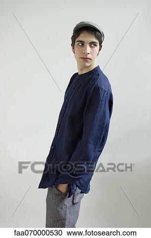 Male standing with hands in pockets, looking over shoulder View Large Photo Image Stock Image - Male standing with hands in pockets, looking over shoulder. Fotosearch