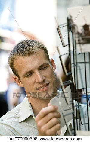 Male tourist looking at postcards View Large Photo Image Stock Photograph - Male tourist looking at postcards. Fotosearch