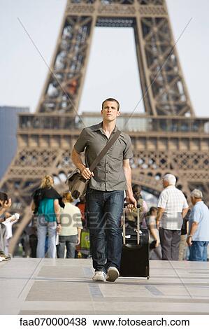 Male tourist walking with luggage, Eiffel Tower, Paris, France View Large Photo Image Stock Photo - Male tourist walking with luggage, Eiffel Tower, Paris, France. Fotosearch