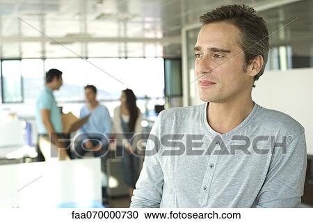 Man in office, looking away in thought View Large Photo Image Stock Image - Man in office, looking away in thought. Fotosearch