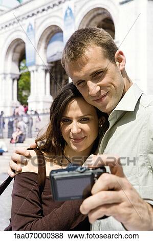 Man photographing himself and his girlfriend with digital camera View Large Photo Image Stock Photo - Man photographing himself and his girlfriend with digital camera. Fotosearch