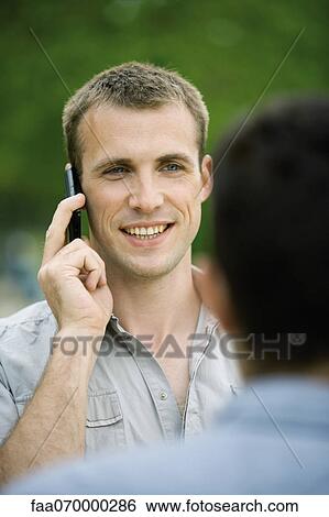 Man talking on cell phone outdoors View Large Photo Image Stock Photograph - Man talking on cell phone outdoors. Fotosearch