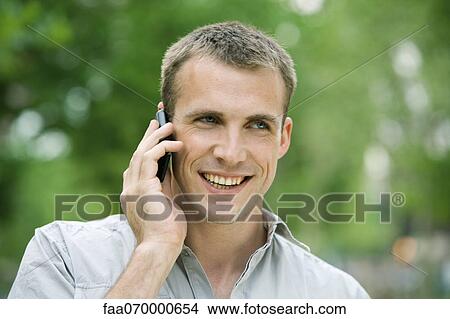 Man using cell phone outdoors View Large Photo Image Picture - Man using cell phone outdoors. Fotosearch