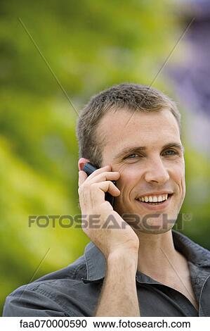 Man using cell phone outdoors View Large Photo Image Stock Image - Man using cell phone outdoors. Fotosearch