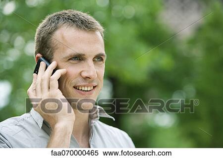 Man using cell phone outdoors View Large Photo Image Stock Photography - Man using cell phone outdoors. Fotosearch