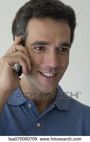 Man using cell phone, smiling View Large Photo Image Stock Photo - Man using cell phone, smiling. Fotosearch