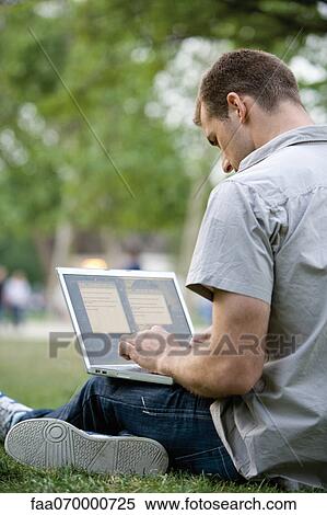 Stock Photography - Man using laptop computer outdoors. Fotosearch
