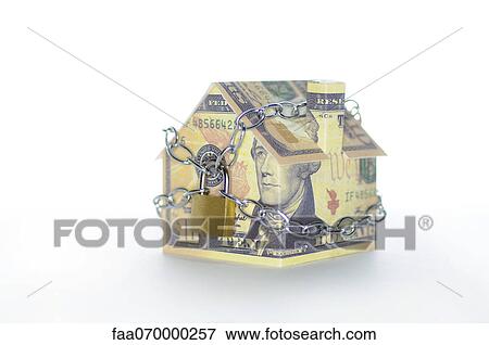 Stock Photo - Model house folded with dollar bills chained and padlocked. Fotosearch