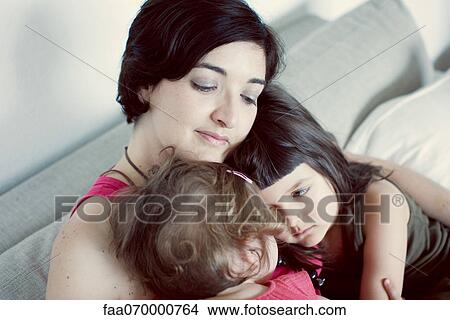 Picture - Mother and daughters embracing. Fotosearch