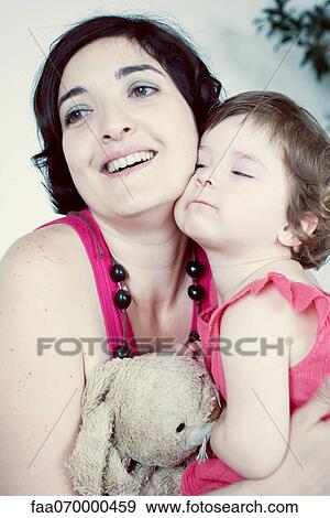 Stock Photo - Mother and young daughter cheek to cheek, portrait. Fotosearch