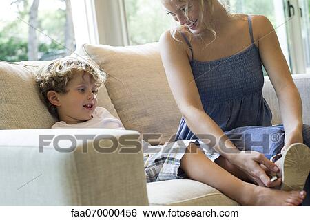 Mother helping young son put on shoes View Large Photo Image Stock Photograph - Mother helping young son put on shoes. Fotosearch