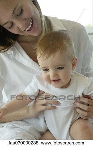 Stock Photo - Mother holding baby on lap. Fotosearch