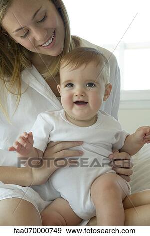 Stock Photo - Mother holding baby on lap. Fotosearch
