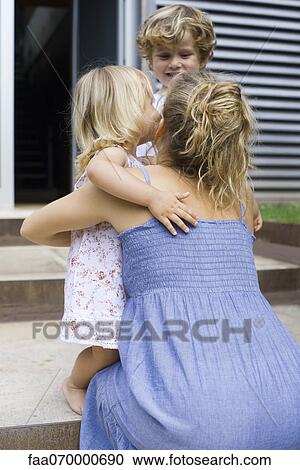 Mother hugging young daughter outdoors View Large Photo Image Stock Image - Mother hugging young daughter outdoors. Fotosearch