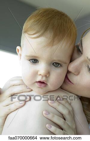 Mother kissing baby's cheek View Large Photo Image Picture - Mother kissing baby's cheek. Fotosearch