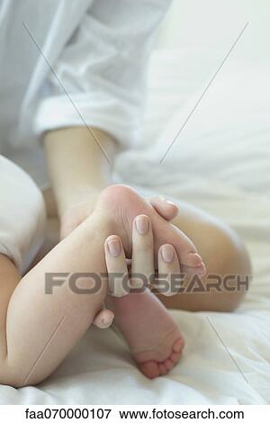 Mother touching baby's foot, cropped View Large Photo Image Stock Photo - Mother touching baby's foot, cropped. Fotosearch
