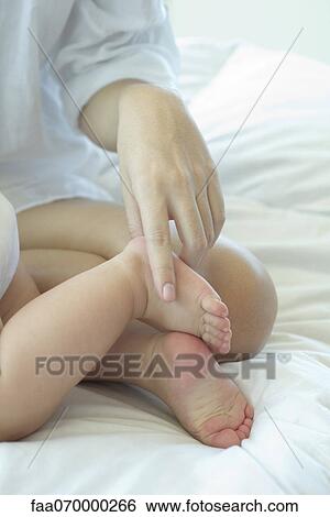 Mother touching baby's foot, cropped View Large Photo Image Stock Photograph - Mother touching baby's foot, cropped. Fotosearch