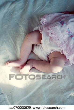 Stock Photo - New born baby girl's legs, cropped, directly above. Fotosearch