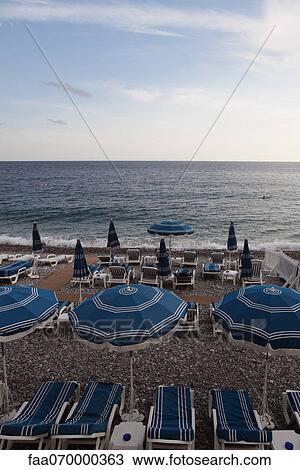 Parasols and empty deckchairs on beach View Large Photo Image Stock Image - Parasols and empty deckchairs on beach. Fotosearch