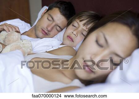 Parents and young son sleeping together in bed View Large Photo Image Picture - Parents and young son sleeping together in bed. Fotosearch