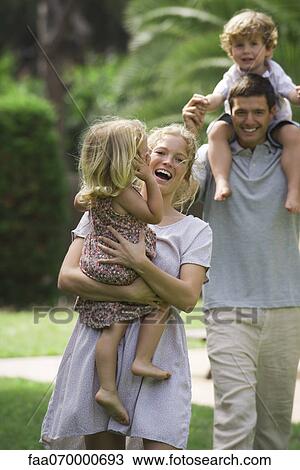 Stock Image - Parents carrying children outdoors. Fotosearch