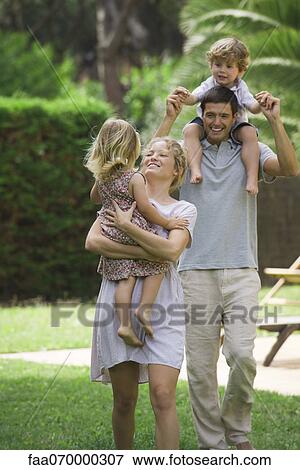 Stock Photo - Parents carrying children outdoors. Fotosearch