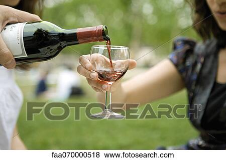 Pouring glass of red wine outdoors View Large Photo Image Stock Photo - Pouring glass of red wine outdoors. Fotosearch