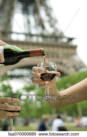 Stock Photo - Pouring glass of red wine outdoors. Fotosearch
