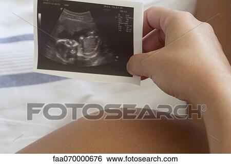 Pregnant woman holding ultrasound, cropped View Large Photo Image Stock Photograph - Pregnant woman holding ultrasound, cropped. Fotosearch