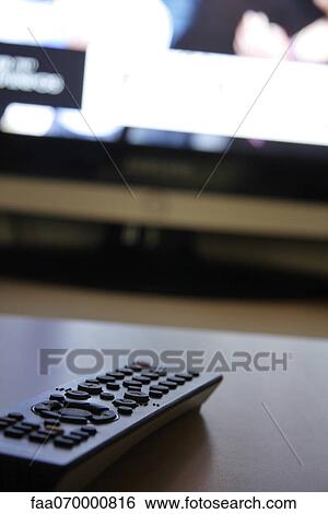 Remote control, television screen in background View Large Photo Image Stock Photograph - Remote control, television screen in background. Fotosearch