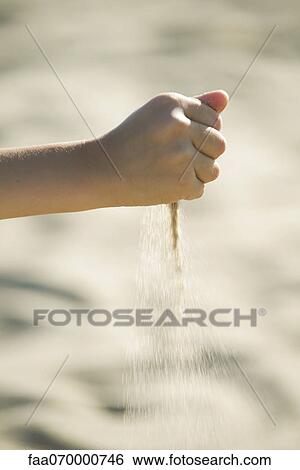 Stock Photograph - Sand spilling from child's hand. Fotosearch