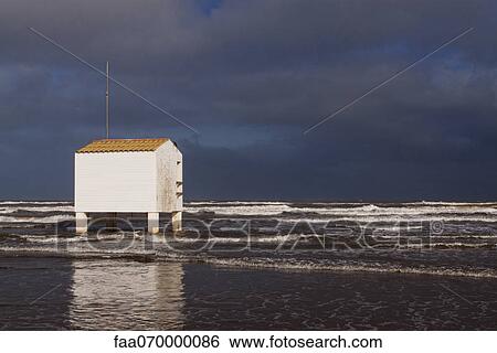 Stock Photograph - Tides and stilt building on beach. Fotosearch