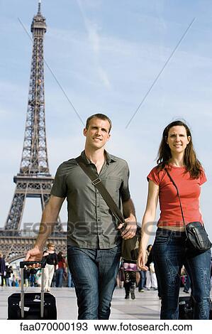 Tourist couple walking with their luggage near Eiffel Tower, Paris, France View Large Photo Image Stock Image - Tourist couple walking with their luggage near Eiffel Tower, Paris, France. Fotosearch