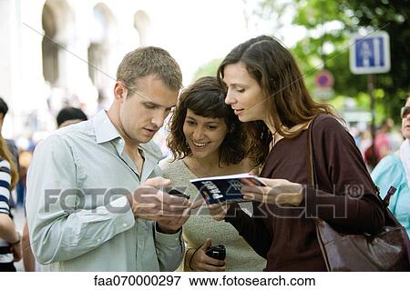 Tourists consulting guidebook View Large Photo Image Stock Photo - Tourists consulting guidebook. Fotosearch
