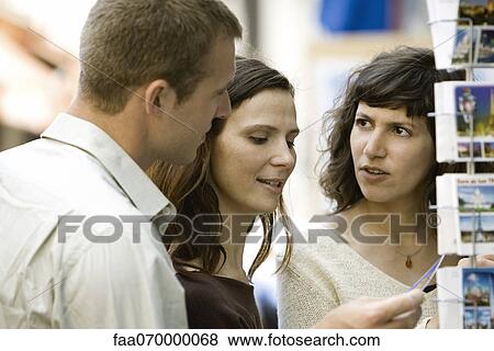 Tourists looking at postcards View Large Photo Image Stock Photo - Tourists looking at postcards. Fotosearch