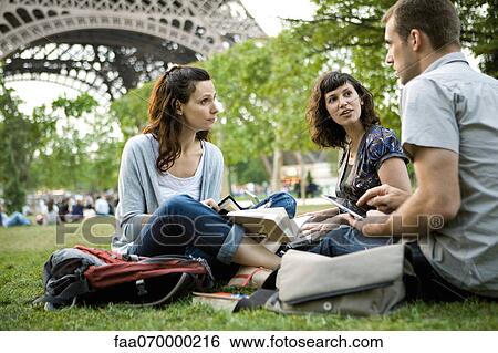 Stock Photograph - Tourists relaxing near Eiffel Tower, Paris, France. Fotosearch