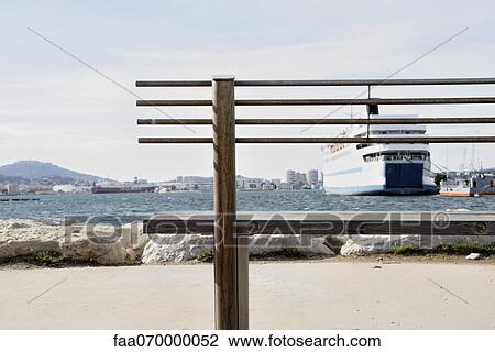 Stock Image - View of harbor through bench. Fotosearch