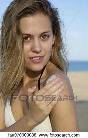 Woman applying sunscreen at the beach View Large Photo Image Stock Photo - Woman applying sunscreen at the beach. Fotosearch
