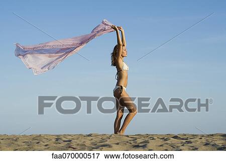 Woman at the beach, holding scarf out in breeze View Large Photo Image Stock Photo - Woman at the beach, holding scarf out in breeze. Fotosearch