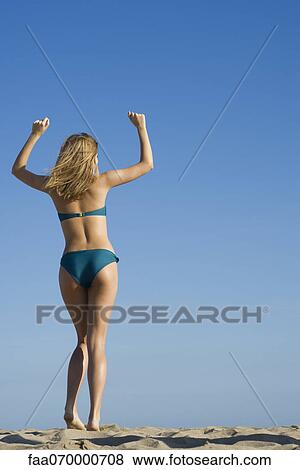 Woman at the beach with arms raised in air, rear view View Large Photo Image Stock Photo - Woman at the beach with arms raised in air, rear view. Fotosearch