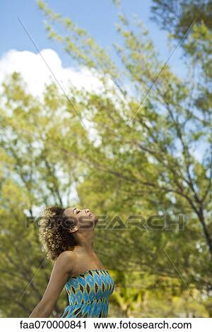 Stock Image - Woman enjoying fresh air outdoors. Fotosearch