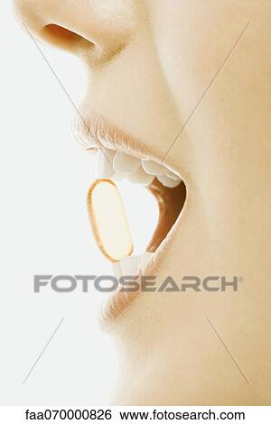 Woman holding vitamin soft gel capsule between teeth, close-up View Large Photo Image Stock Photograph - Woman holding vitamin soft gel capsule between teeth, close-up. Fotosearch