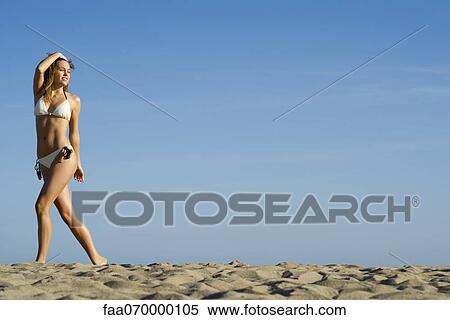 Stock Photography - Woman in bikini walking at the beach. Fotosearch