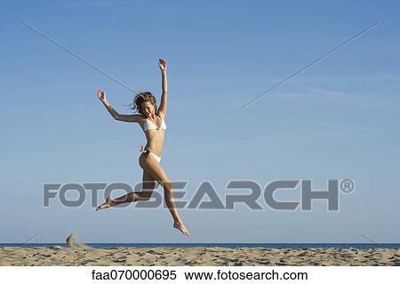 Woman jumping in midair at the beach View Large Photo Image Stock Photography - Woman jumping in midair at the beach. Fotosearch