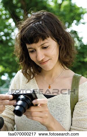 Woman looking at digital camera View Large Photo Image Stock Photo - Woman looking at digital camera. Fotosearch