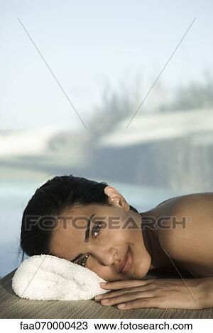 Woman lying on stomach at spa, relaxing, smiling at camera View Large Photo Image Stock Image - Woman lying on stomach at spa, relaxing, smiling at camera. Fotosearch