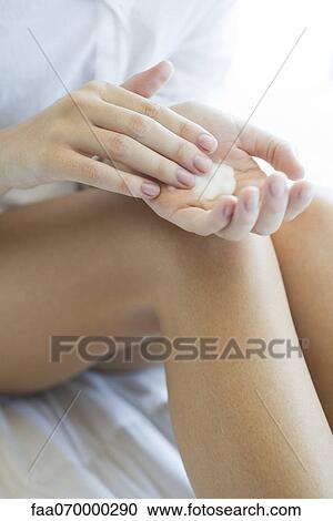 Stock Image - Woman moisturizing legs, cropped. Fotosearch