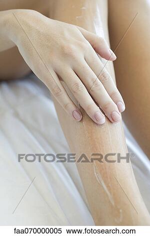 Woman moisturizing legs, cropped View Large Photo Image Stock Photography - Woman moisturizing legs, cropped. Fotosearch